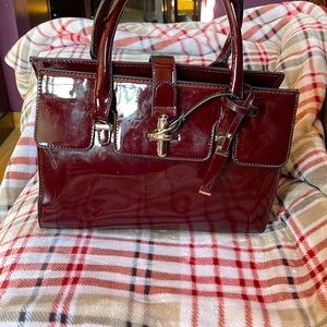 Burgundy patten leather handbag with Gold color hardware.